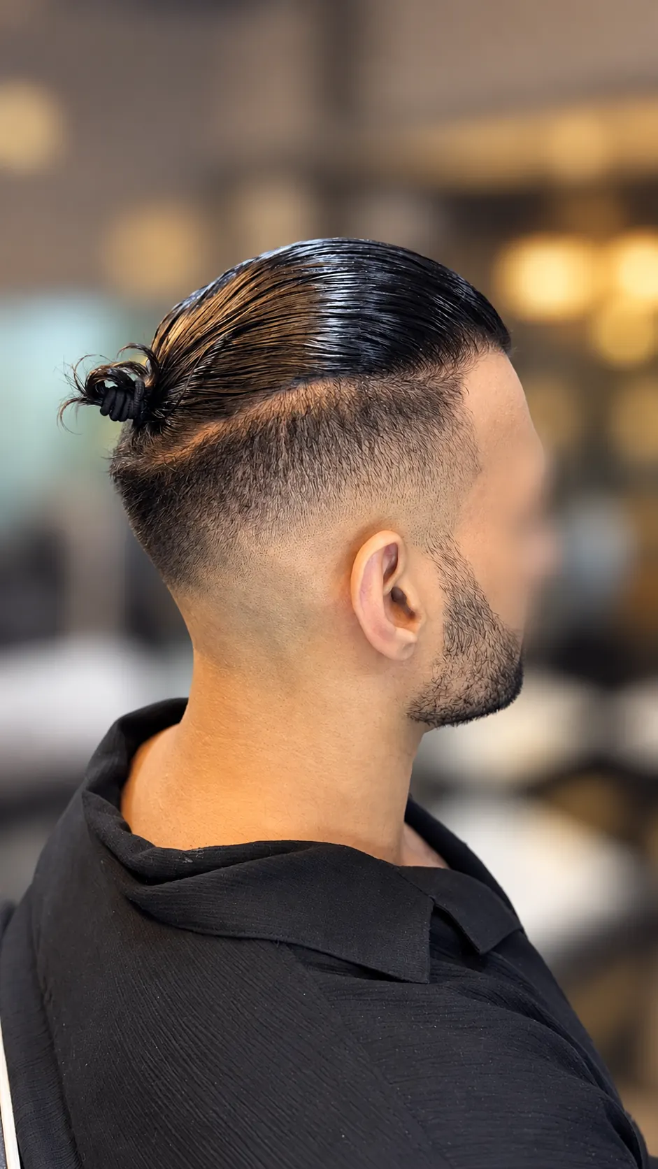 Director Stylist skin fade and tied-back hairstyle